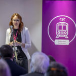 68dfd15b9e508 68dfd15b9e50asc Alice At Lectern.jpg